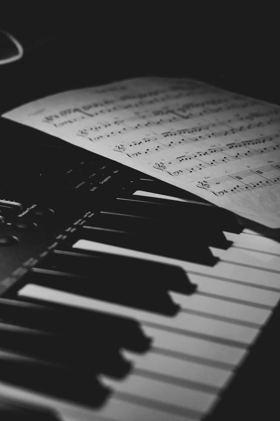 Clape de pian cu partitura muzicala, simbol al coloanei sonore in productie video profesionala.