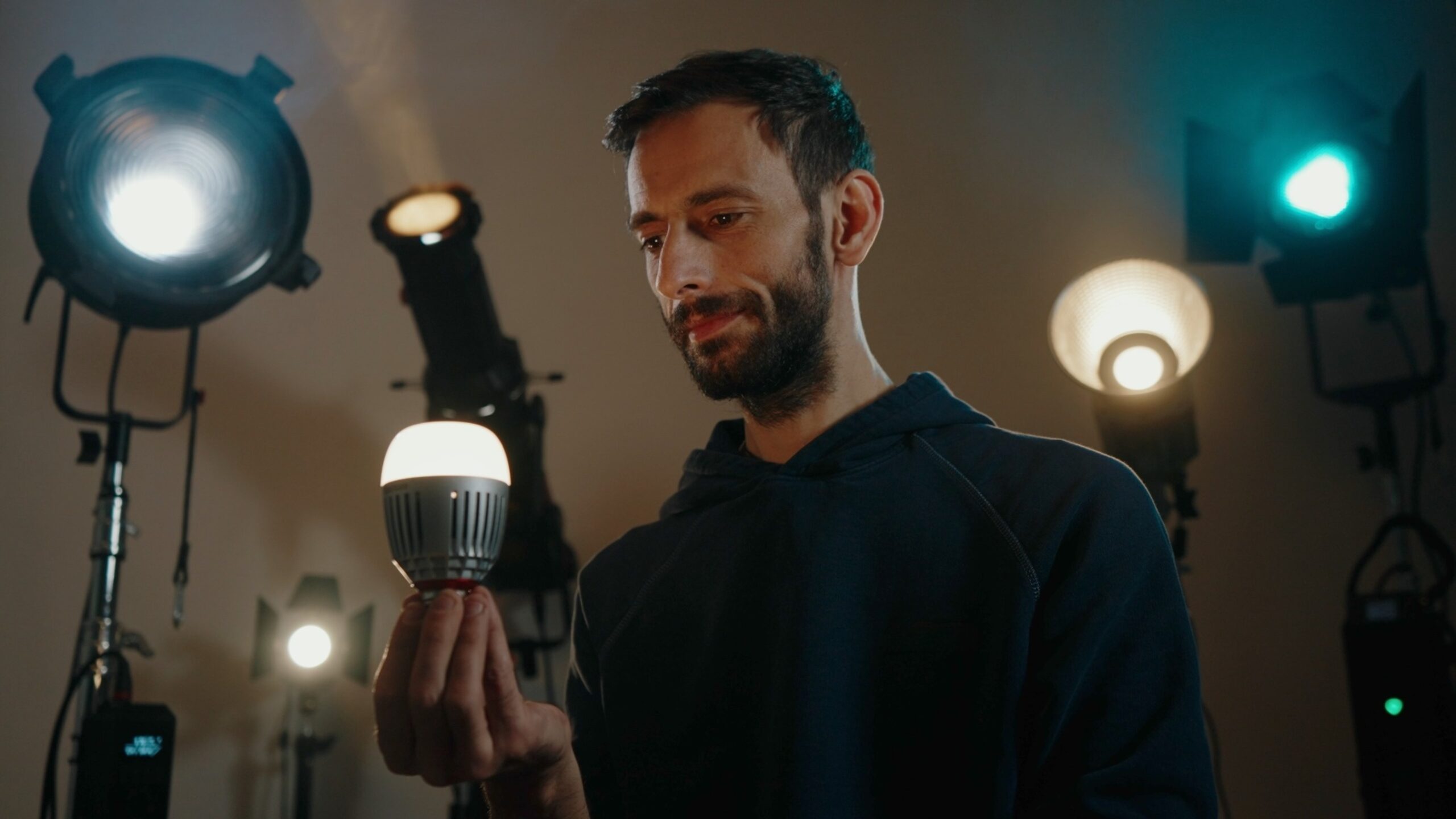 Gabriel Bostan, videograf în București, ține un bec LED într-un studio cu lumini profesionale